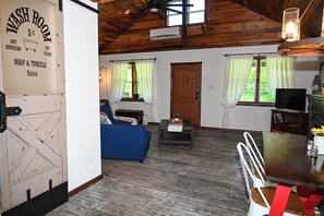 A rustic interior with a living area, a washroom, and a dining space.