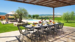 A covered outdoor dining area with a pool and garden view. - Villa Flaminia 8 2 - Emma Villas (Gualdo Cattaneo)
