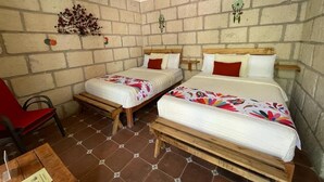 A room with two beds, each with a wooden headboard, white bedding, and red pillows. There is a red chair and a small table with a menu on it. - La Posada de Don Luis (Ezequiel Montes)