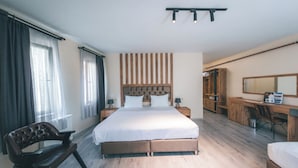A modern hotel room with a large bed, a desk, a chair, and a wardrobe. - Grand 464 Otel (Rize)