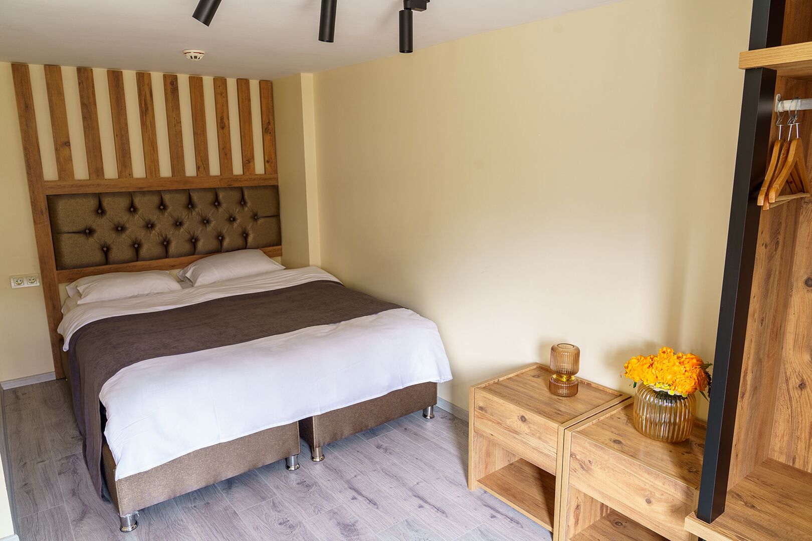 A bedroom with a bed, bedside table, and a wooden headboard.