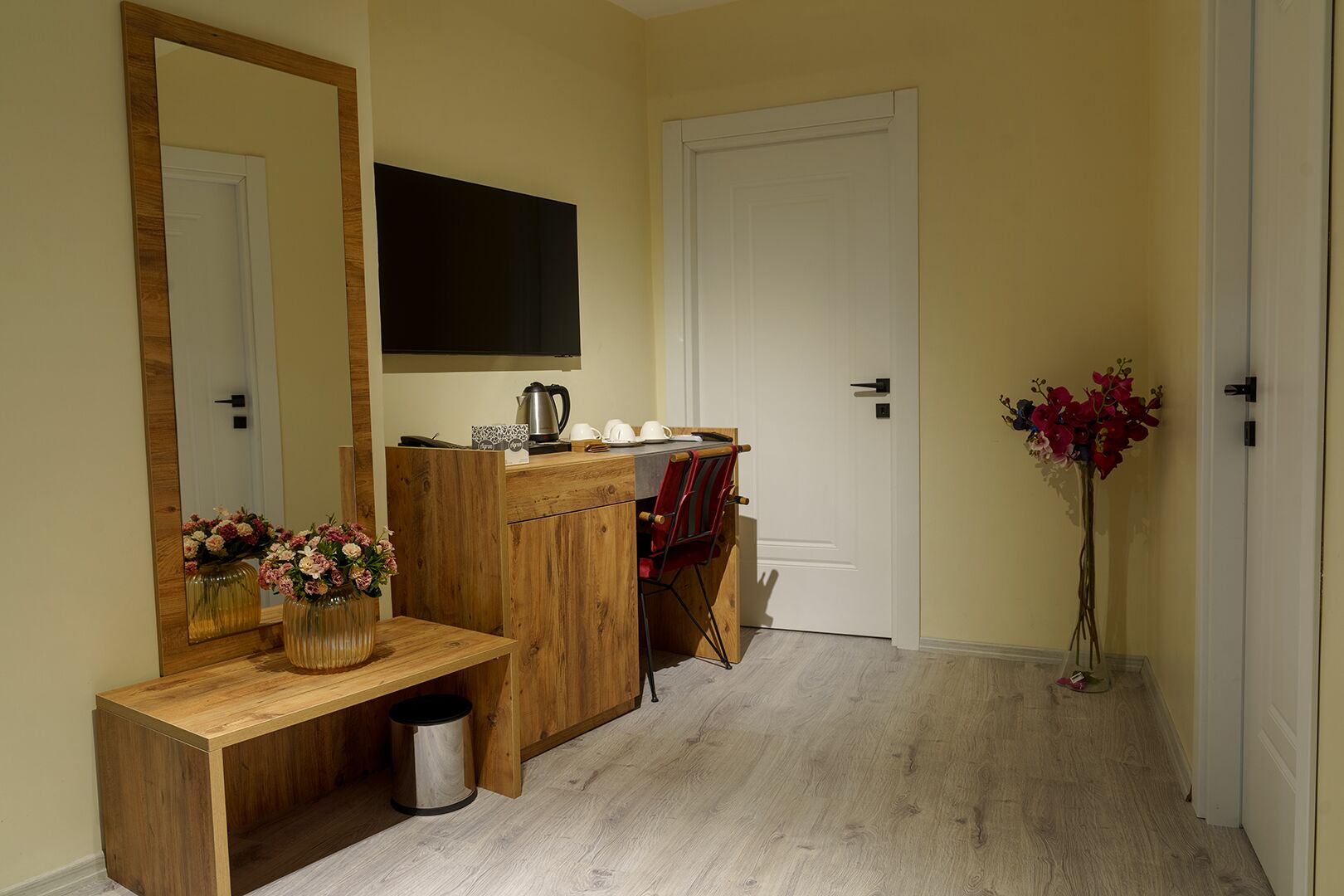 A bathroom with a wooden vanity, a mirror, a sink, and a toilet.