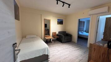 Une chambre à coucher comprenant un lit, un bureau, une chaise, un miroir et une armoire.