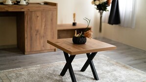 A small wooden table with a vase of dried flowers and a black pot. - Grand 464 Otel (Rize)