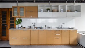 Una cocina moderna con armarios de madera, una encimera blanca y un lavamanos de acero inoxidable.