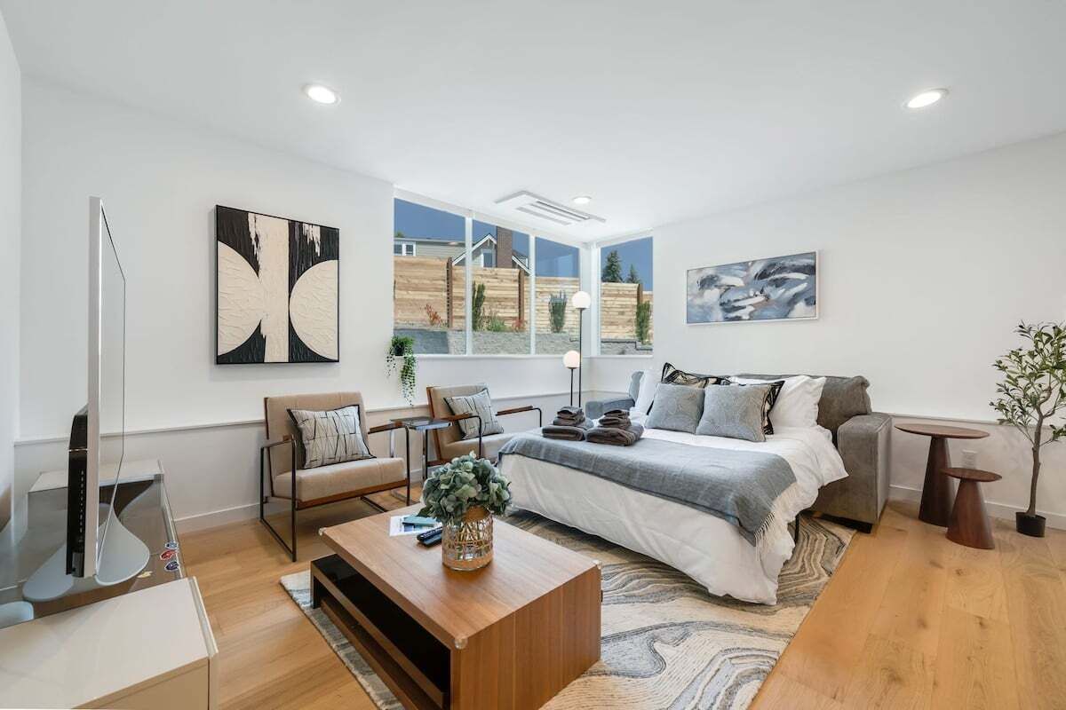 A modern living room with a large bed, a coffee table, and a TV.