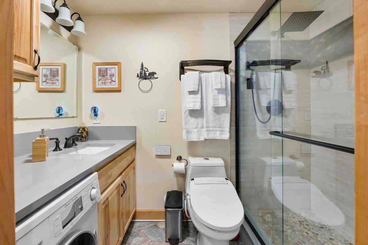 Een kleine badkamer met toilet, wastafel en douchecabine.