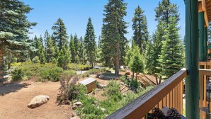 A forested area with a wooden deck and a dirt path. - TahoeCozy Woodland Retreat • Pool • Hot Tub • Beach (Tahoe Vista)