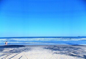 A beach with clear skies and calm waves. - Condomínio Praias de Ubatuba (Ubatuba)