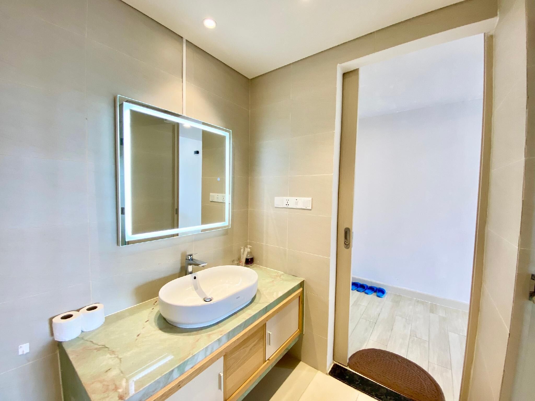 Une salle de bain moderne avec un grand miroir, un lavabo et un espace douche.