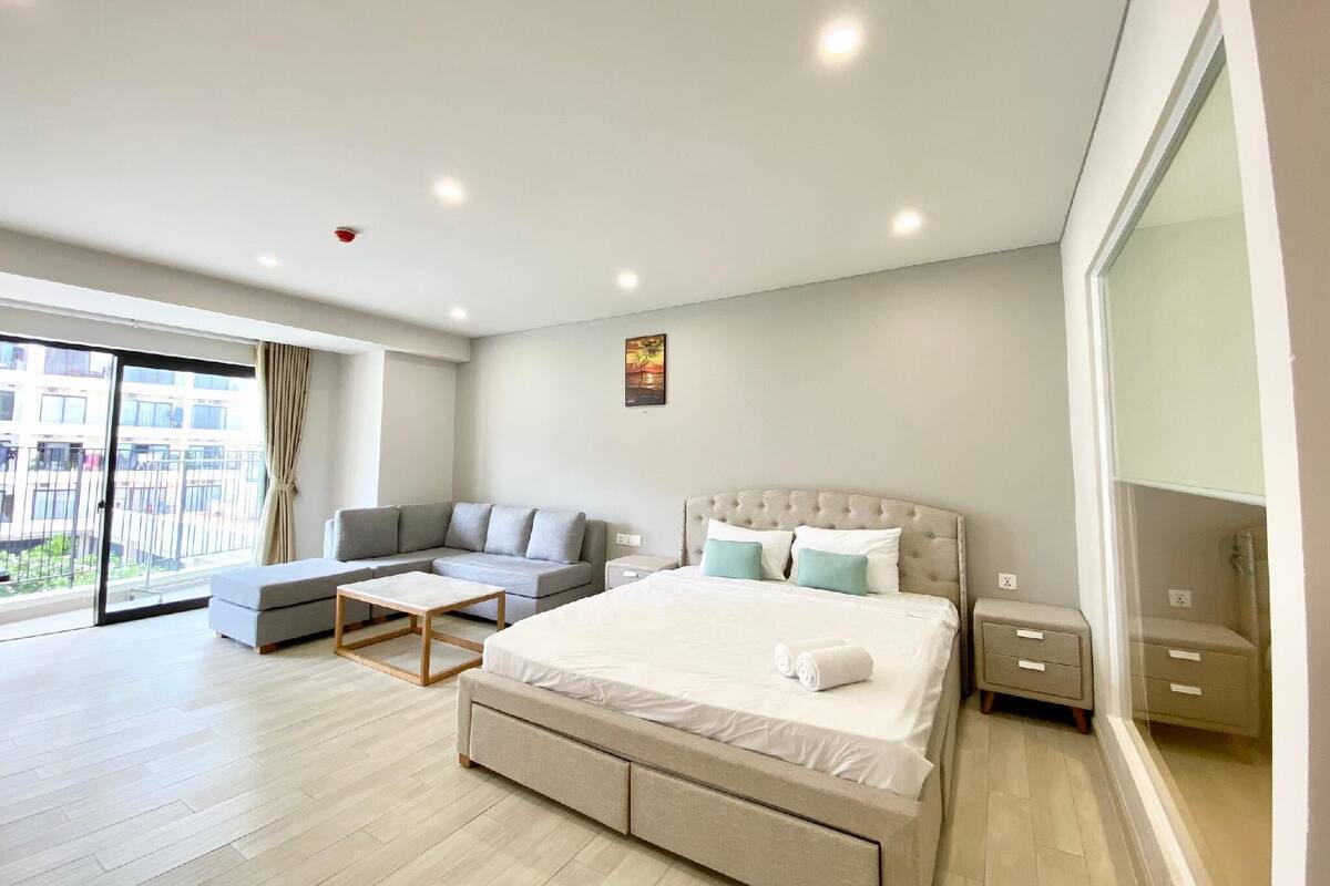 Ein modernes Hotelzimmer mit einem großen Bett, einer Couch und einem kleinen Tisch.