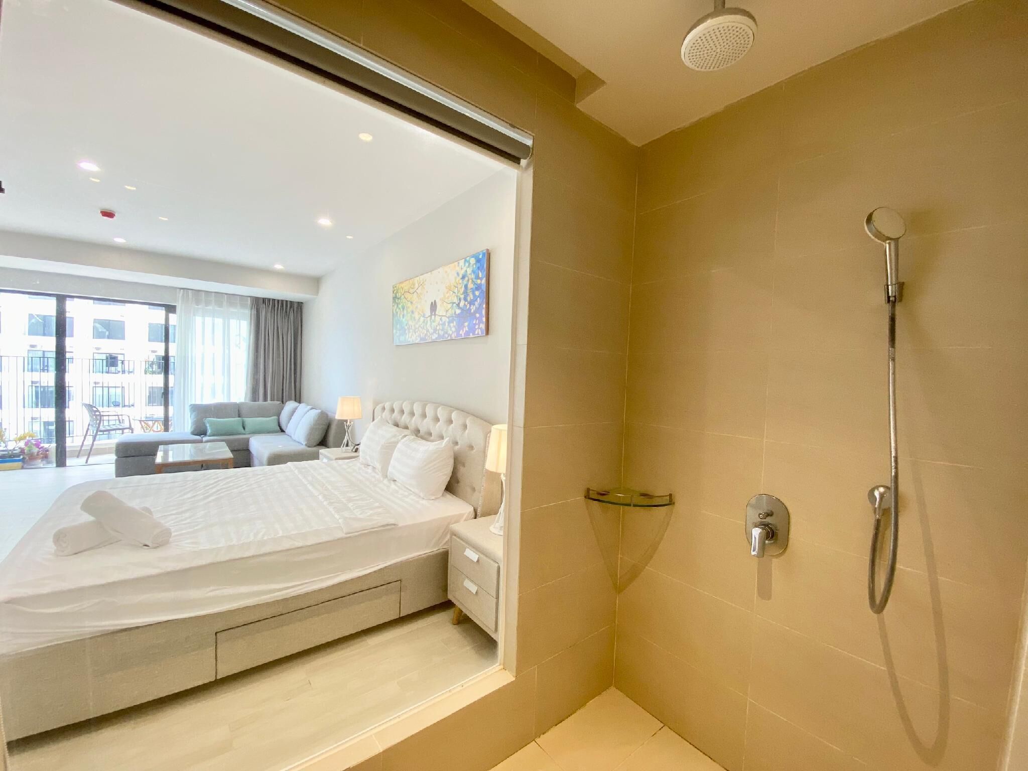 A hotel room with a large bed, a shower, and a view of the city.