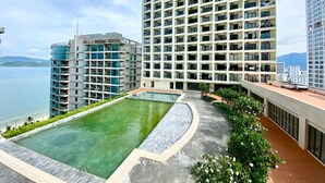 A high-rise hotel with a rooftop pool, offering views of the sea and mountains. - Wise Stay Gold Coast Apartment (Nha Trang)