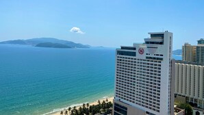 A hotel with a view of the ocean and a distant mountain range. - Wise Stay Gold Coast Apartment (Nha Trang)