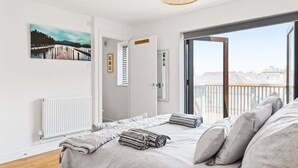 Et soveværelse med en seng, et vindue, en radiator og et billede på væggen.
