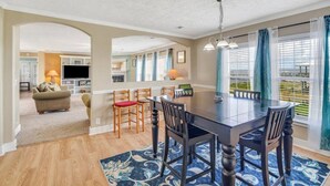 A spacious living area with a dining table, chairs, a sofa, and a TV. - Family Friendly Waterfront Home | Private backyard (New Orleans)