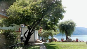 A pathway leading to a house with a view of a lake and mountains. - Beautiful Beach front cottage near Nelson, BC (Nelson)