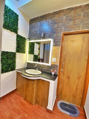 Features a bathtub, sink, and mirror with lighting.