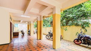 Un pasillo con suelo de baldosas, pilares y motocicletas estacionadas.