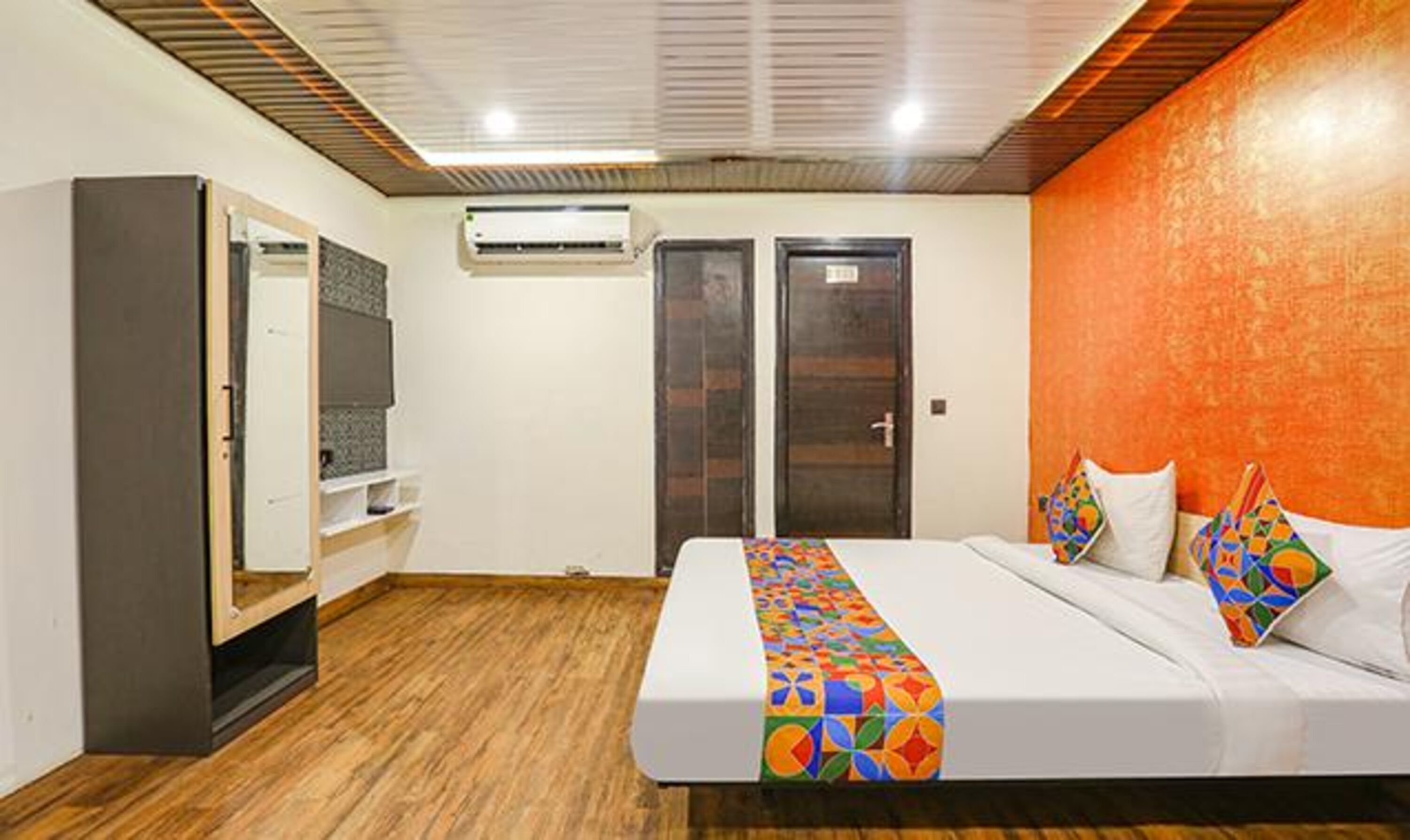 Une chambre d’hôtel équipée d’un lit, d’une armoire, d’un appareil de climatisation et d’une porte.