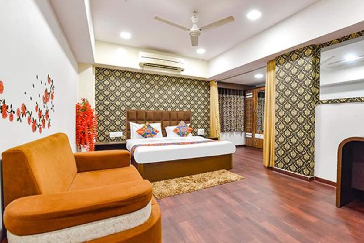 Une chambre d’hôtel moderne, équipée d’un lit, d’un canapé, d’un bureau et dotée de murs à motifs.