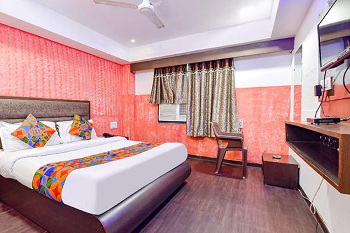 Une chambre d’hôtel avec un grand lit, un bureau et une chaise.