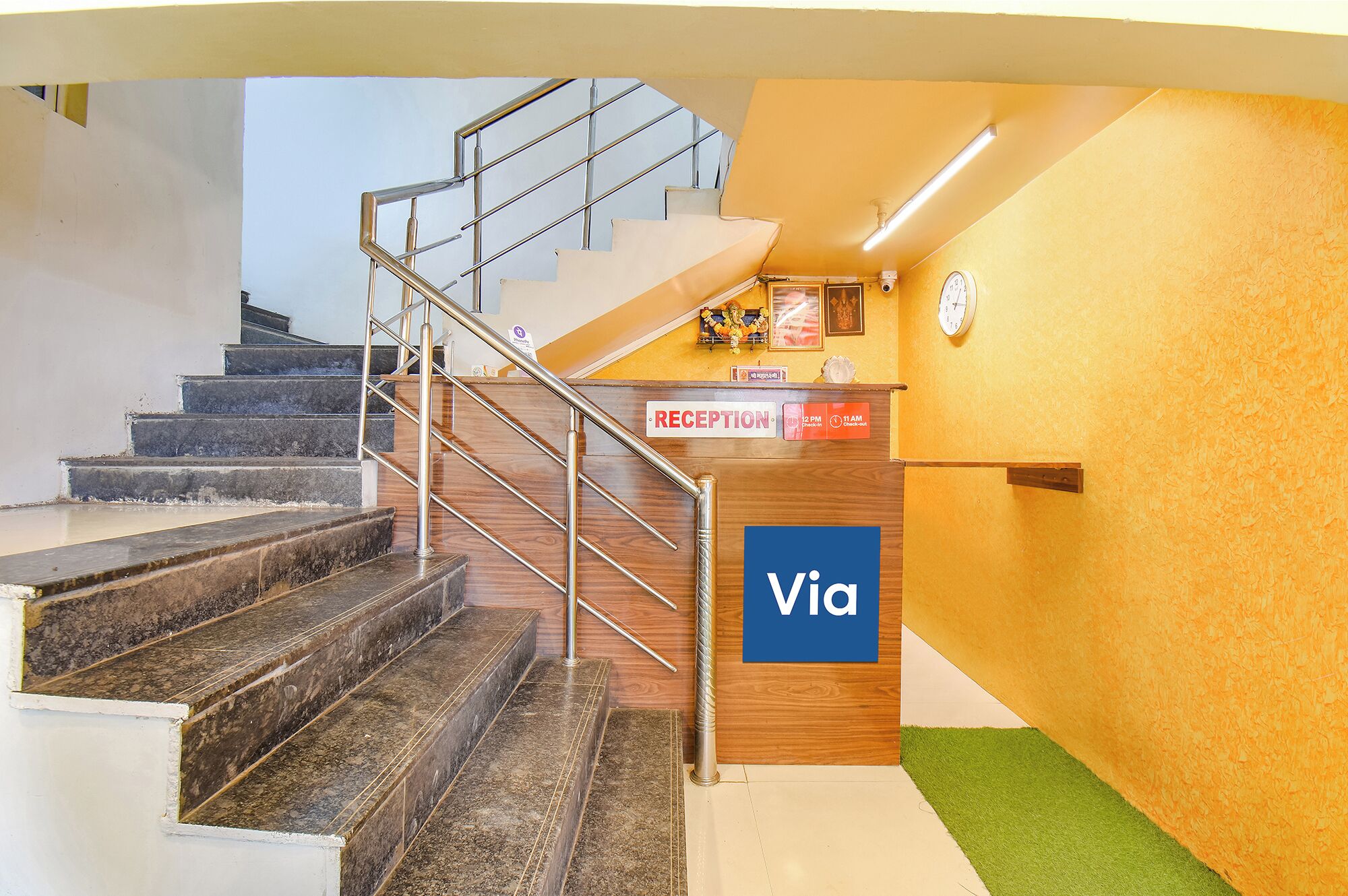 A reception area with a staircase, a reception desk, and a clock on the wall.