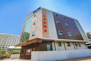 Ein mehrstöckiges Hotel mit modernem Design, mit einem auffälligen 'HOTEL'-Schild und 'ROOMS'-Beschilderung an der Fassade.