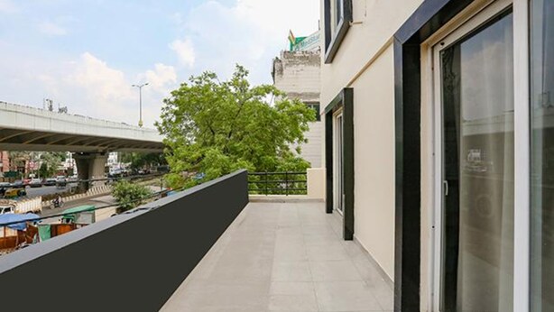 A balcony with a view of a busy street and a bridge. - FabExpress Meera Residency (New Delhi)