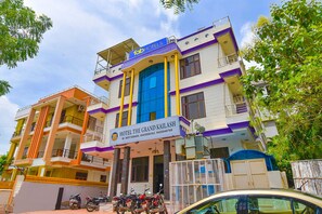 Un hotel de varios pisos con balcones y un letrero llamativo que dice 'Hotel The Grand Kailash'.
