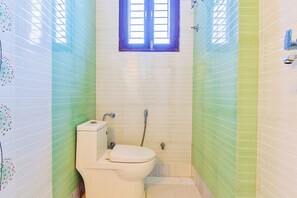 Un baño pequeño con inodoro, ventana y ducha.