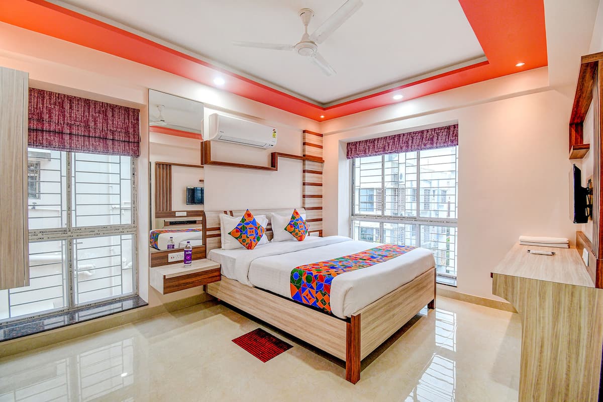 A modern bedroom with a bed, bedside tables, a wardrobe, and a window with a view.