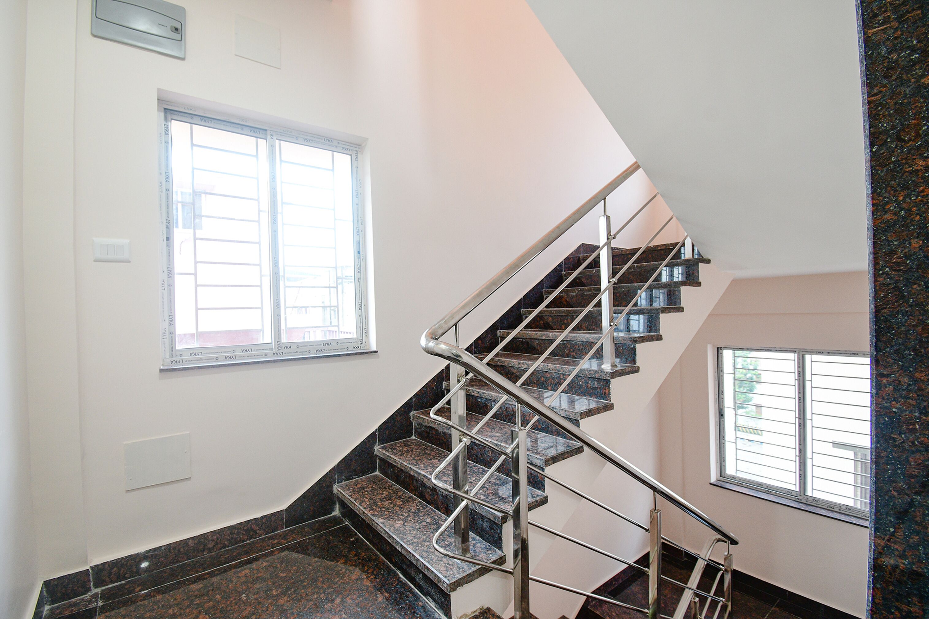 A staircase with metal railings and granite steps, leading to an upper floor.