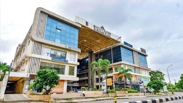 A modern building with a fitness center, a pharmacy, and a salon. - Fabexpress Solitaire (Surat)