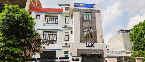 A multi-story building with a sign for 'fabHOTELS' and 'JMD' on the facade.