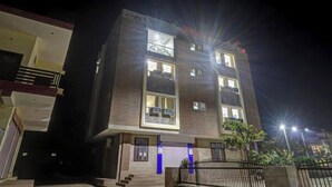 A multi-story building with a flat roof, large windows, and a gated entrance. - Hotel Ravi Residency (Bharatpur)