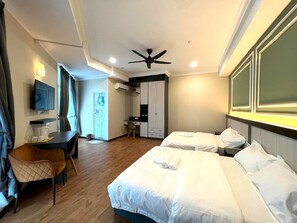 A hotel room with two beds, a desk, a chair, a television, and a ceiling fan. - Townhouse OAK Dey Hotel (Kota Bharu)