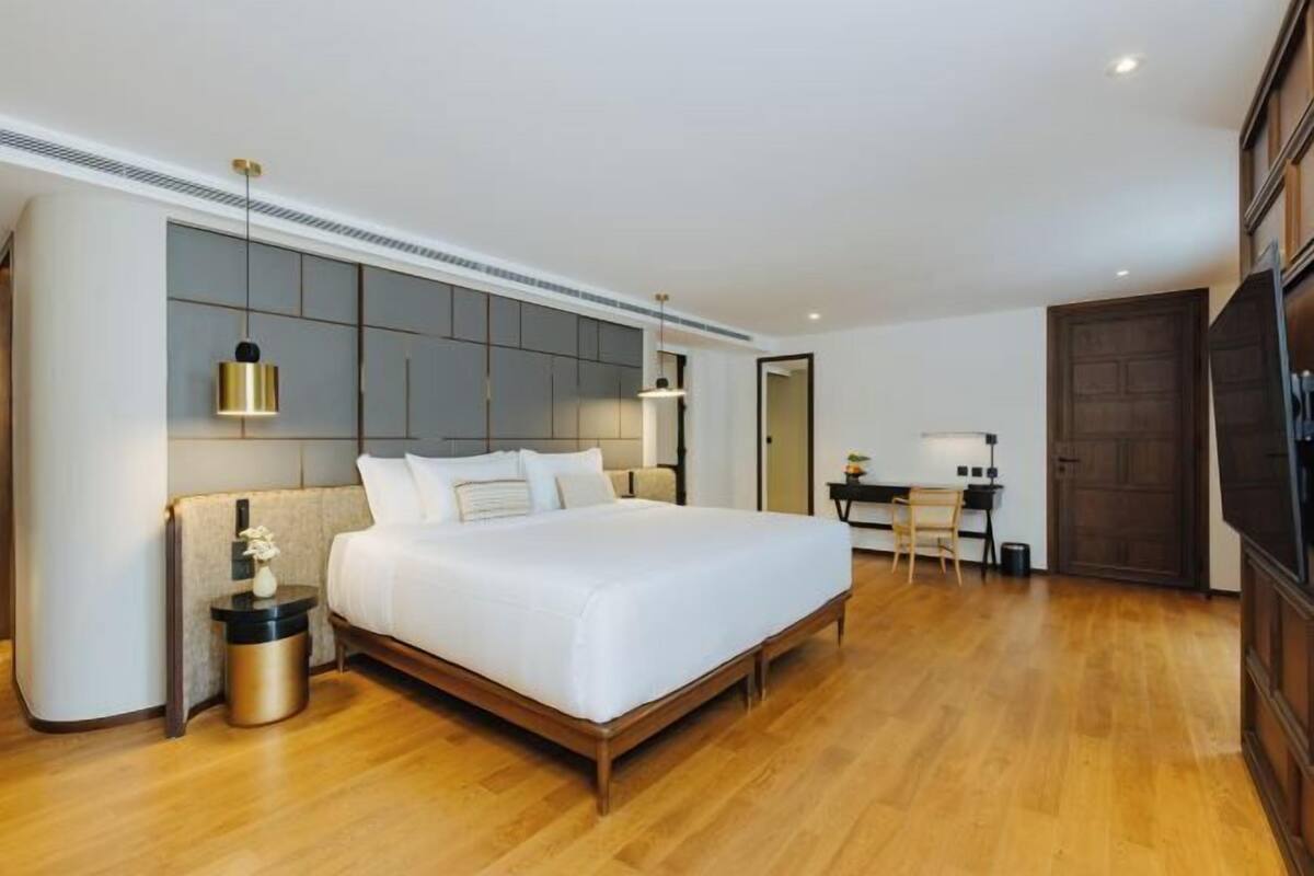 Ein modernes Hotelzimmer mit einem großen Bett, einem Schreibtisch und einem Fernseher.