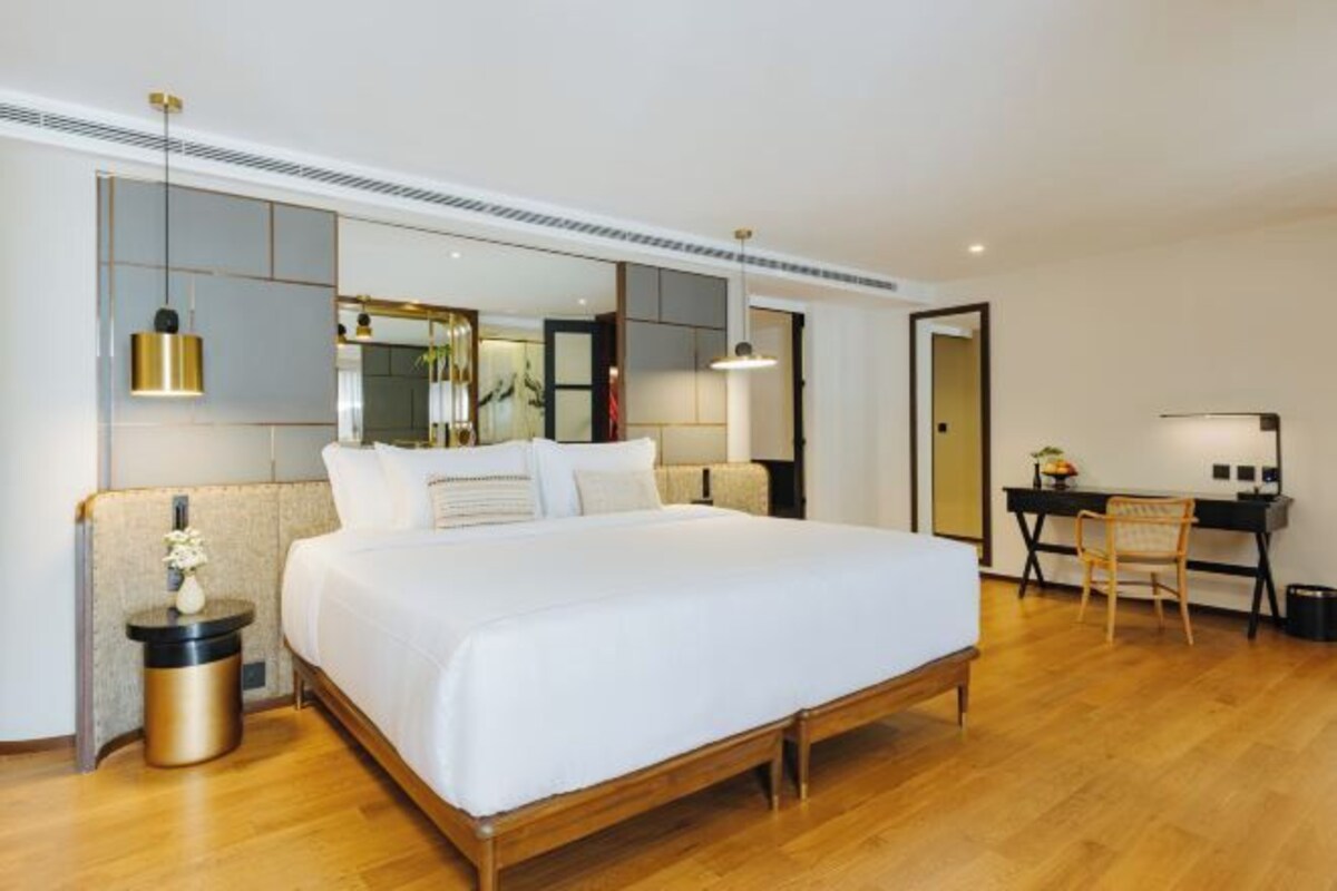 Een moderne hotelkamer met een groot bed, een bureau en een stoel.
