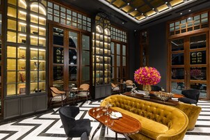 A luxurious lobby with a large sofa, seating area, and a decorative vase.