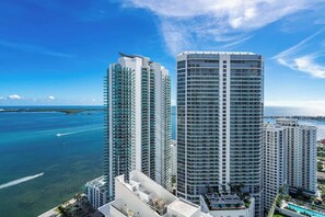A high-rise hotel with multiple floors, a rooftop pool, and a view of the ocean. - Majestic Penthouse w/ Ocean & City Views (Miami)