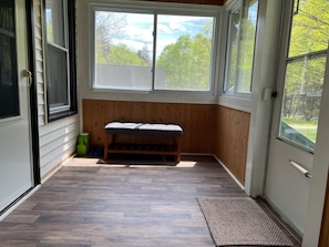 A room with a bench, large windows, and a wooden floor. - Catskills Brookside Cottage (Margaretville)