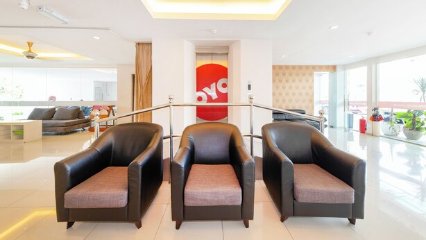A modern lobby with three leather armchairs, a chandelier, and a large window. - Collection O 88 Hotel (Malacca City)