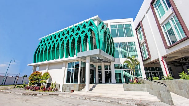 A modern building with a distinctive green facade and large windows. - Capital O 92604 Hotel Uin Syariah Near Kampus UIN Mataram (Mataram)