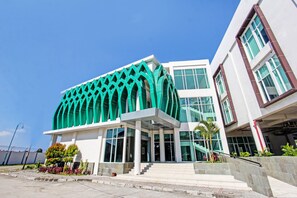 A modern building with a distinctive green facade and large windows.