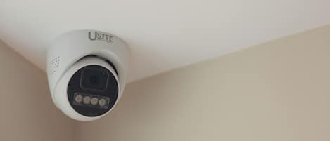 A ceiling-mounted security camera with a visible brand name.
