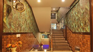 Uma escadaria com piso de mármore e paredes de tijolo, que dá acesso a um andar superior.