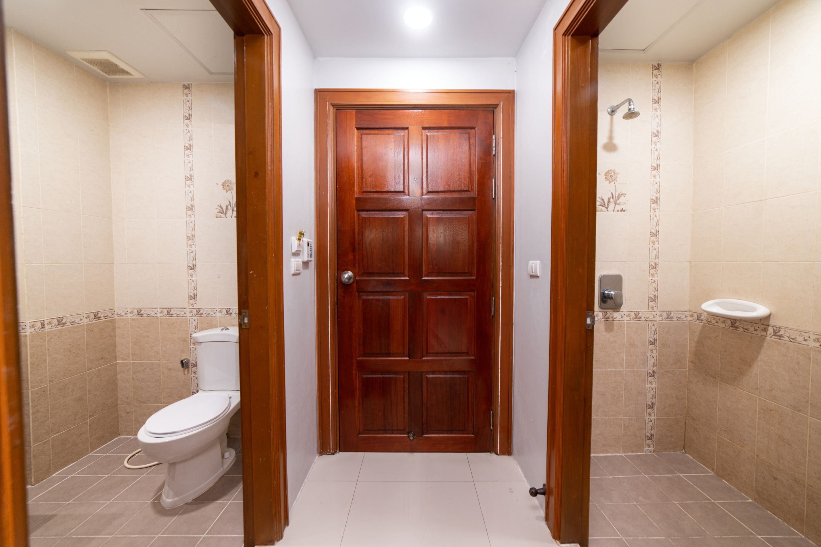 Ein Badezimmer mit Holztür, Toilette und Waschbecken.