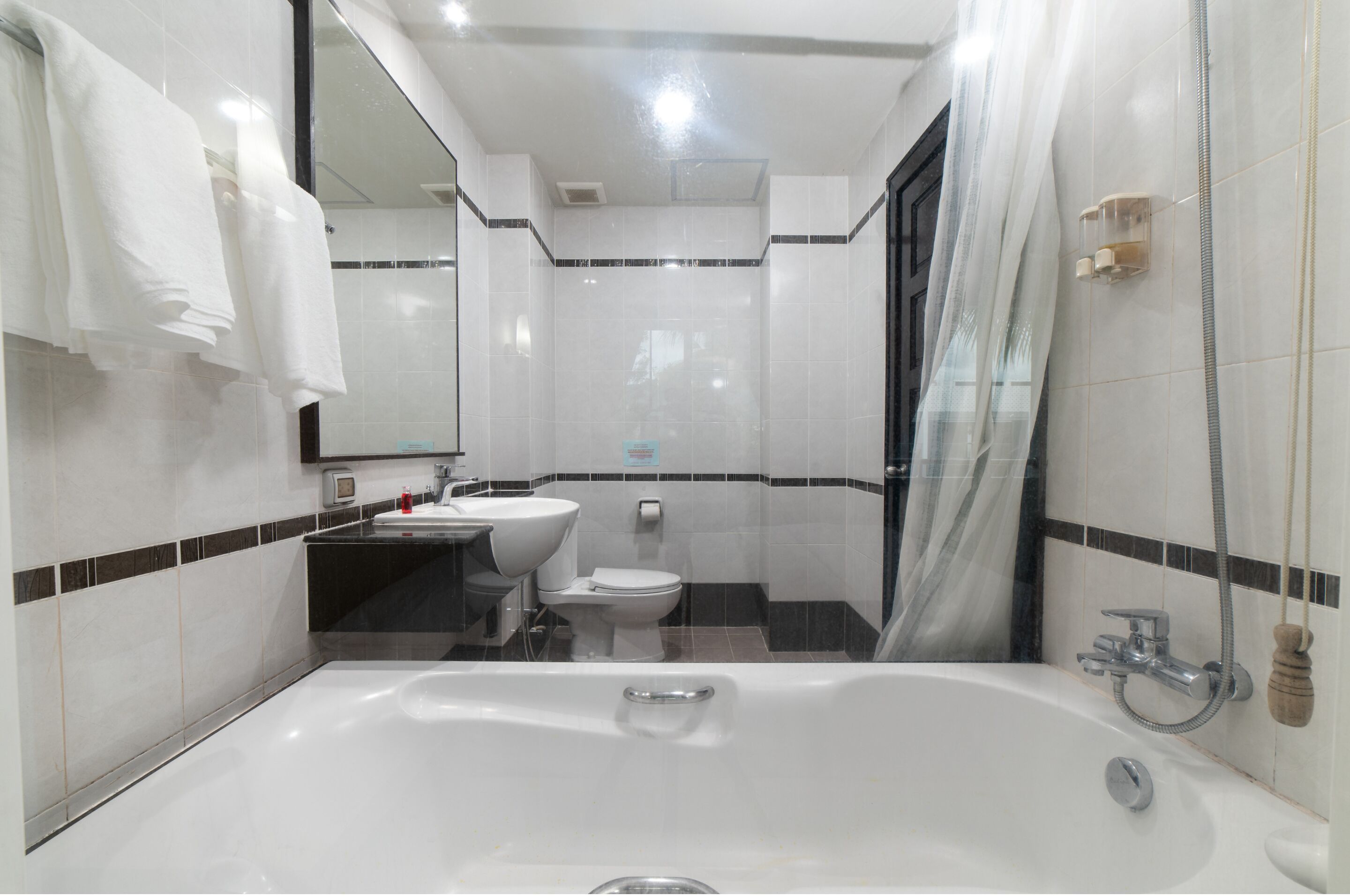 A modern bathroom with a bathtub, a sink, and a toilet.