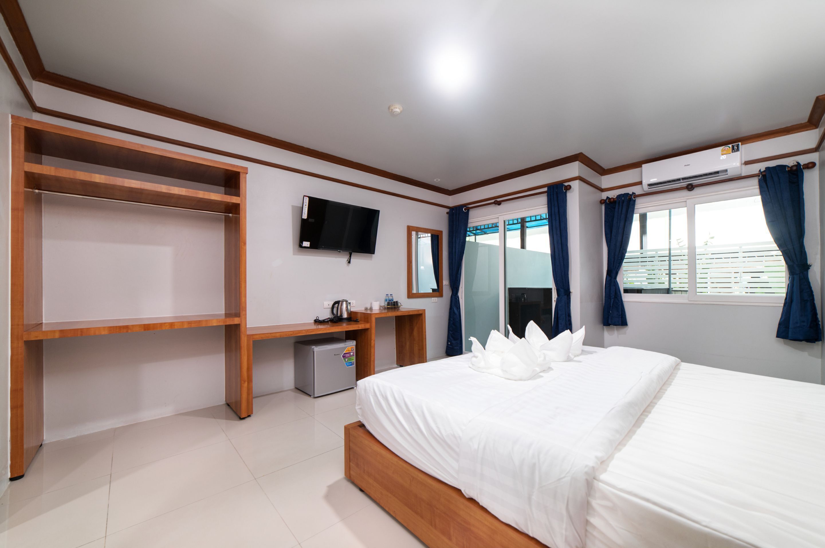 A hotel room with a bed, a TV, a desk, and a wardrobe.